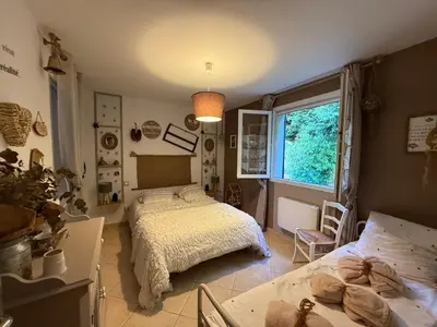 a bedroom with a bed and a table and a window at Mon rêve in Les Martys