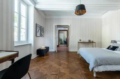 a bedroom with a bed and a table and a piano at Maison d'hôtes ÔVillage in Ouveillan