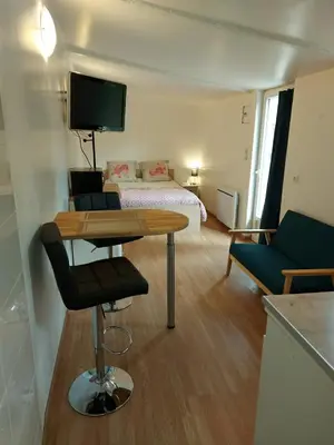 a small room with a bed and a table with a chair at studio au calme wifi 600m centre ville parking privé in Castres