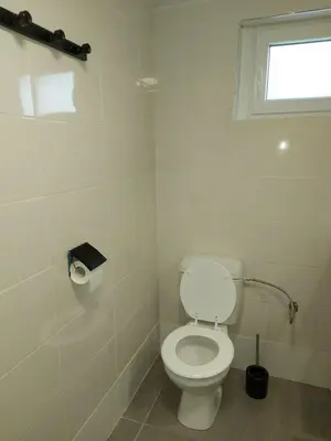 a white bathroom with a toilet and a window at studio au calme wifi 600m centre ville parking privé in Castres