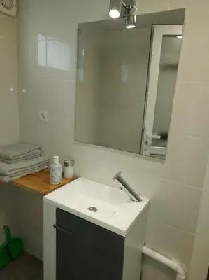 a white bathroom with a sink and a mirror at studio au calme wifi 600m centre ville parking privé in Castres