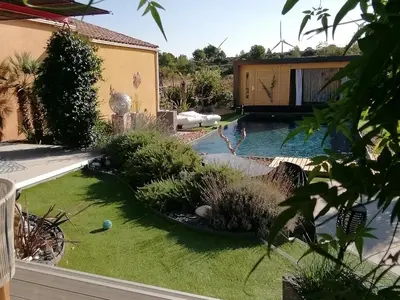 a backyard with a swimming pool and a garden at Studio Camille in Sainte-Vallière