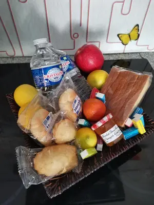 a basket of food with a bottle of water and fruit at Studio Camille in Sainte-Vallière