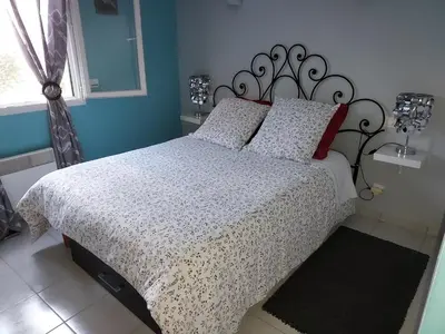 a bedroom with a bed with a black and white comforter at Cher Micheée et Bernard in Camplong-dʼAude