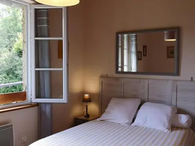 a bedroom with a bed with a mirror and a window at Gite des Kathares in Montferrier