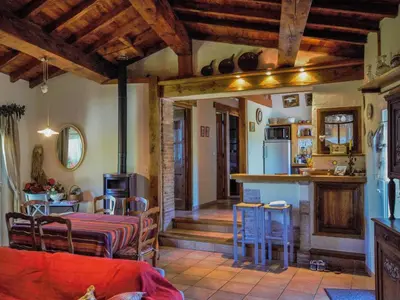 a kitchen and a living room with a table and chairs at Gite des Kathares in Montferrier