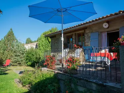 a house with a blue umbrella on a balcony at Gite des Kathares in Montferrier