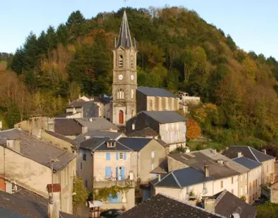 a town with a clock tower in front of a hill at Studio meublé Viane in Viane