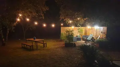 a picnic table in a yard at night with lights at VILLA LOUNA 4 étoiles in Ventenac-Cabardès