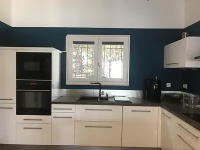 a kitchen with white cabinets and a sink and a window at VILLA LOUNA 4 étoiles in Ventenac-Cabardès