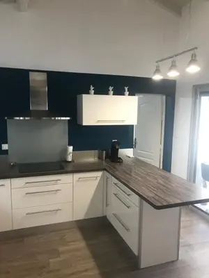 a kitchen with white cabinets and a wooden counter top at VILLA LOUNA 4 étoiles in Ventenac-Cabardès