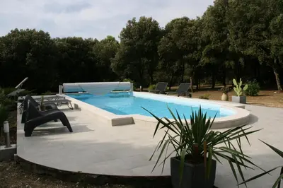 a swimming pool in a yard with chairs around it at VILLA LOUNA 4 étoiles in Ventenac-Cabardès