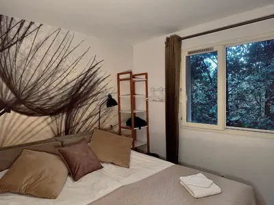 a bedroom with a bed and a large window at Marie Jean Chambre d'hôtes & Gîte in Oupia