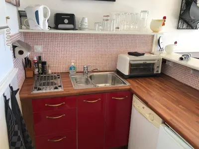 a small kitchen with a sink and a microwave at Marie Jean Chambre d'hôtes & Gîte in Oupia