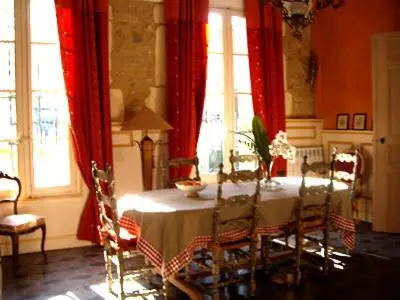 a dining room with a table and red curtains at La Sorga de Vida in Quarante