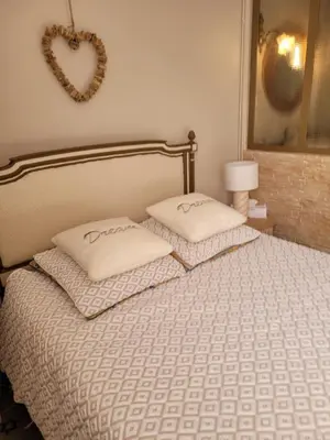 a bedroom with a bed with two pillows and a heart mirror at La Sorga de Vida in Quarante