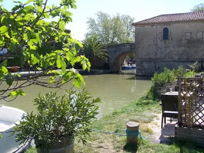 a body of water with a building and a bridge at La Sorga de Vida in Quarante