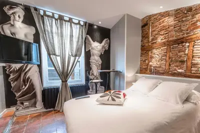 a bedroom with a bed and a tv in a room at Europe Hôtel in Castres