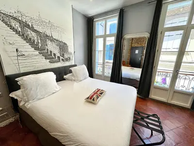a bedroom with a bed with a flag on it at Europe Hôtel in Castres