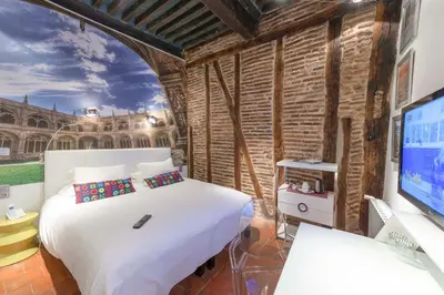 a bedroom with a white bed and a tv at Europe Hôtel in Castres