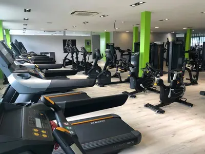 a gym with a bunch of treadms and cardio machines at Europe Hôtel in Castres