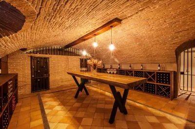 a large room with a wooden table in a wine cellar at Château de Roquefoulet Luxury Guesthouse & Spa in Montgeard