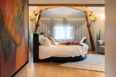a bedroom with a bed with a wooden canopy at Château de Roquefoulet Luxury Guesthouse & Spa in Montgeard