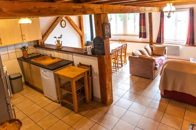 a kitchen and living room with a table and a counter at GITE AUTOMNE in Le Soulié