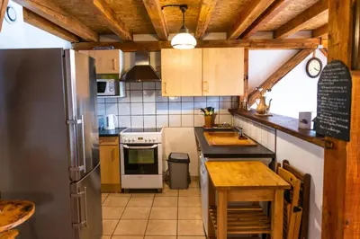 a kitchen with a refrigerator and a table in it at GITE AUTOMNE in Le Soulié