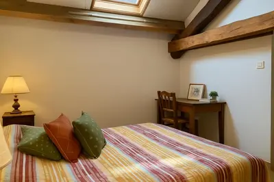 a bedroom with a bed and a desk with a table at GITE AUTOMNE in Le Soulié