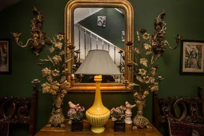 a lamp on a table in front of a mirror at Carcassonne Bed and Breakfast du Palais in Carcassonne