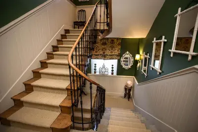 a winding staircase with wooden railings and green walls at Carcassonne Bed and Breakfast du Palais in Carcassonne