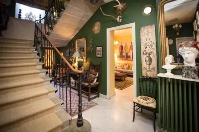 a hallway with a staircase and a room with chairs at Carcassonne Bed and Breakfast du Palais in Carcassonne