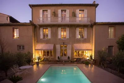 a large building with a swimming pool in front of it at Carcassonne Bed and Breakfast du Palais in Carcassonne