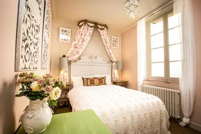a bedroom with a white bed and a vase with flowers at Carcassonne Bed and Breakfast du Palais in Carcassonne