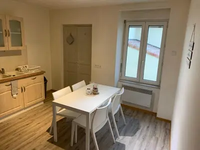 a kitchen with a white table and white chairs at Ravissant Appartement T3 hypercentre de Mazamet in Mazamet