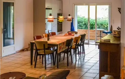 a kitchen and dining room with a table and chairs at 2 Bedroom Awesome Home In Berlou in Berlou