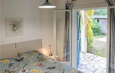 a bedroom with a bed and a sliding glass door at 2 Bedroom Awesome Home In Berlou in Berlou