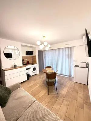 a living room with a table and a kitchen at Studio Plage du Grazel in Gruissan