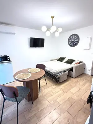a living room with a bed and a table and chairs at Studio Plage du Grazel in Gruissan