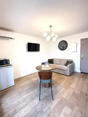 a living room with a table and a couch at Studio Plage du Grazel in Gruissan