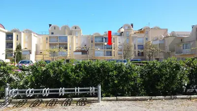 a bench in front of a large building at Studio Plage du Grazel in Gruissan