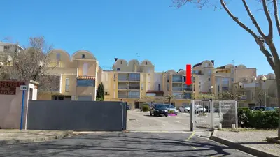 a parking lot in front of a large building at Studio Plage du Grazel in Gruissan
