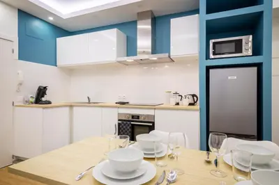 a kitchen with a wooden table with plates and wine glasses at Superbe appartement plein centre, calme, Netflix in Mirepoix
