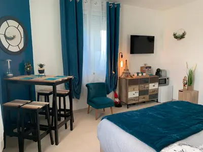 a bedroom with a bed and a table and a desk at La Liberté in Narbonne