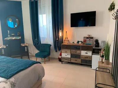a bedroom with a bed and a dresser with a television at La Liberté in Narbonne