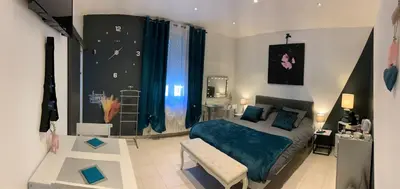 a bedroom with a bed and a bench in it at La Kloé in Narbonne