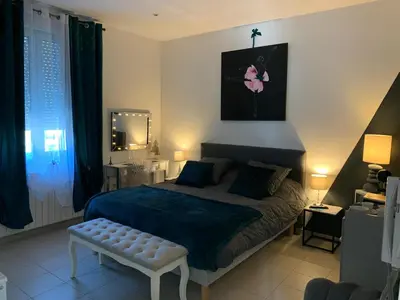 a bedroom with a bed and a bench in it at La Kloé in Narbonne
