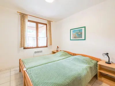 a bedroom with a green bed and a window at Holiday Home La Maison d'Antoine by Interhome in Salles-d'Aude