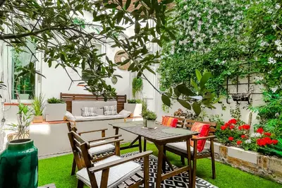 a patio with a table and chairs and flowers at RétroMirabeau 